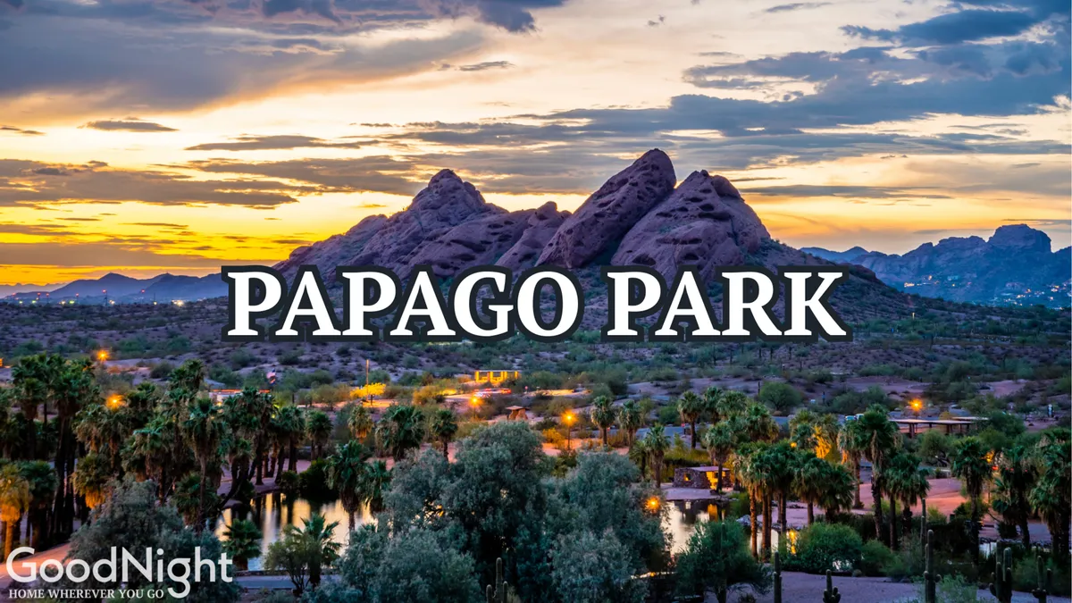 A scenic view of Papago Park mountains at sunset, framed by palm trees and a colorful sky. The image evokes the tranquility and natural beauty of one of Tempe's nearby outdoor attractions.